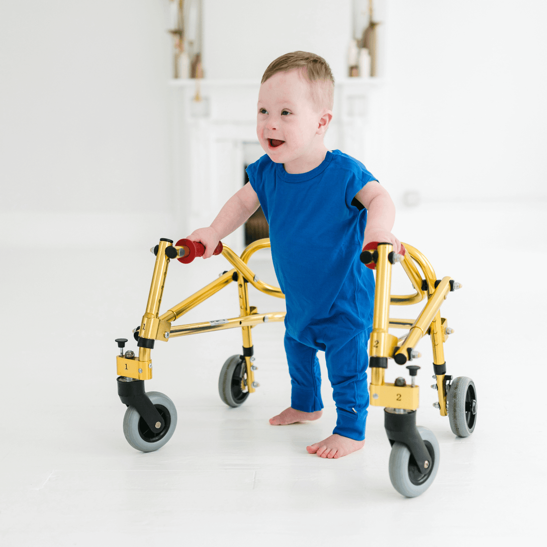 smiling-toddler-in-blue-zippy-leg-romper-set-using-a-walker,-showcasing-playful-mobility-and-style.